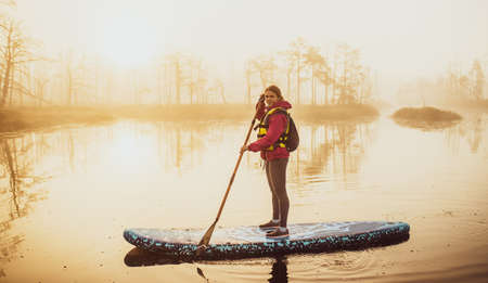 Atmospheric landscape. Fog over swamp. Sup-boarding.