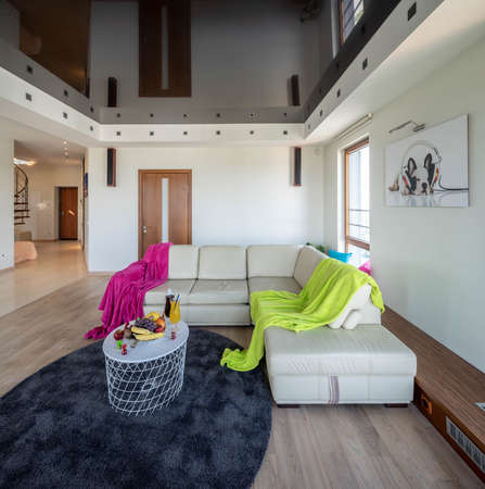View of cozy sofa and small table with fruits and drinks in modern luxury apartment.の写真素材