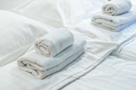 Bed. Soft white pillows. White towels. Blurred background.の写真素材