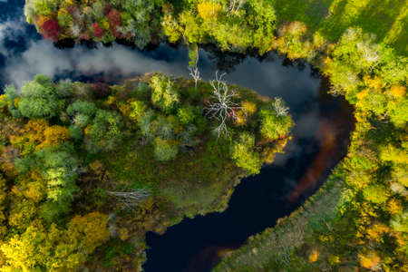 Beautiful autumn landscape. View from above. River Jugla, field and trees. Latvian nature.の写真素材