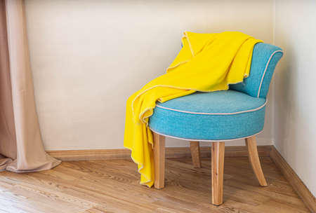 Close-up of cozy soft blue chair in the corner. Modern interior of bedroom. Yellow plaid.の写真素材