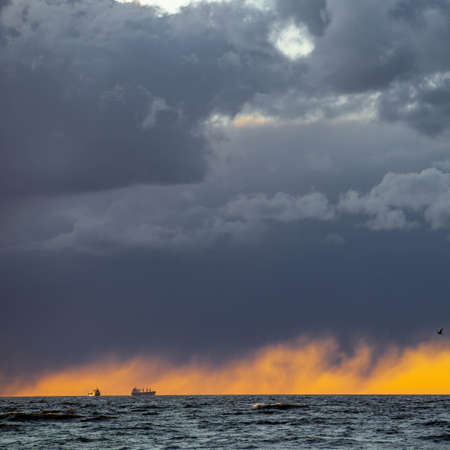 Dramatic sunset over Baltic sea. Ships in the distance. Cloudy sky.の写真素材
