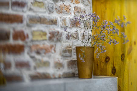 Modern loft interior of bathroom. Brick wall. Close-up of shelf with flower.の写真素材