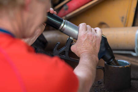 Man refueling tractor at the gas station. Pumping petrol with fuel pump. Close-up.の写真素材