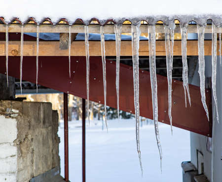 Close-up of icicles on the roof. Winter concept.の写真素材