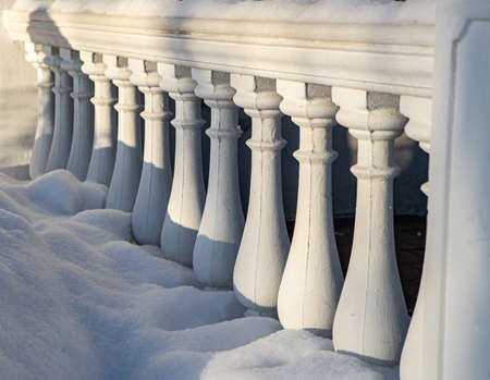 Close-up of white classic balustrade with snow.の写真素材