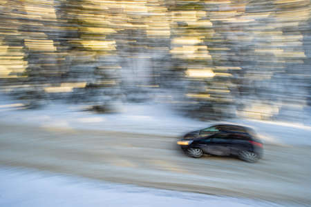 Scenic landscape of winter forest. Pine and spruce trees covered by snow. Car on road in motion. Beautiful nature.の写真素材