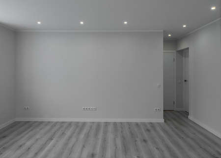 Modern light interior of empty renovated room with white walls. Heating battery under window....