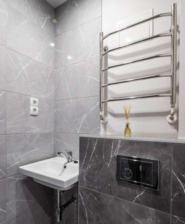Modern interior of bathroom in luxury apartment. Grey marble tile. White sink. Aroma sticks.の写真素材