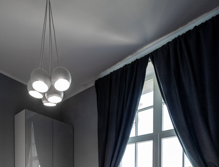 Modern interior in grey tones of bedroom. View of ceiling with stylish chandelier.の写真素材