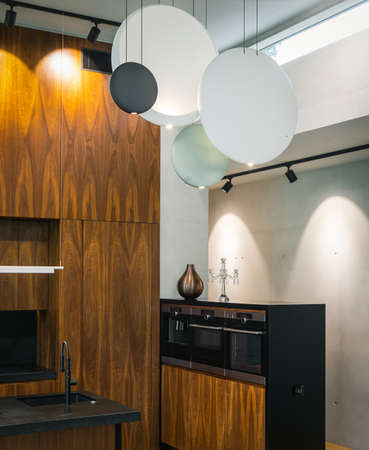 Modern interior of wooden kitchen with sink and black counter.の写真素材