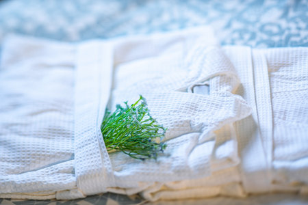 Close-up of white folded bathrobes on bed in hotel.の写真素材