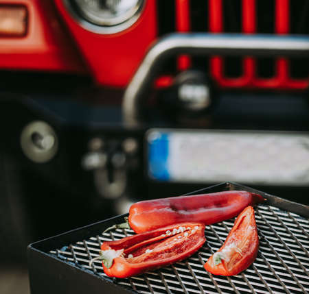 Sliced hot pepper on grill. Red car on background. Close-up.の写真素材