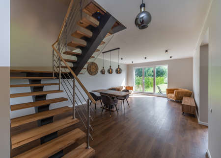 Modern interior of private house. Living room with table and chairs.