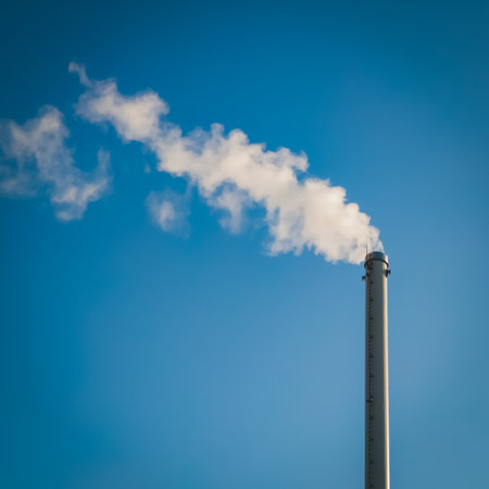 Factory chimney with smoke. Industrial pipe. Blue sky at sunny day. Air pollution/の写真素材