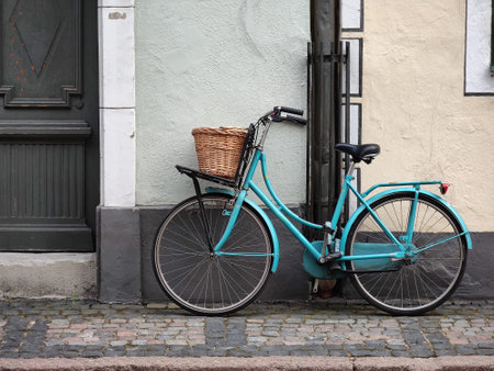 Vintage bicycle with wicker basket against the wall of the building.の写真素材
