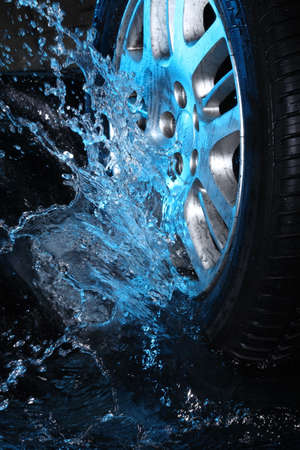 Car's wheel with blue water on black backgroundの写真素材