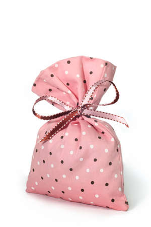 Pink polka-dot pouch tied with a bow on white backgroundの写真素材