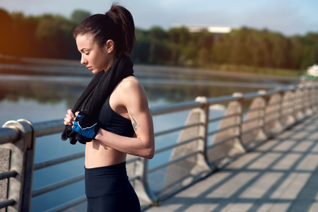 Young beautiful and strong woman resting after an active workout at the summer park. Sports concept. Healthy lifestyleの写真素材