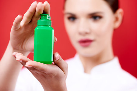 Doctor holds an antiseptic in his hands. Nurse shows a sanitizer in green packagingの写真素材