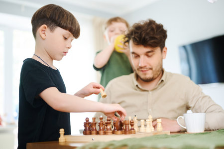 Father teaching son how to play chess. Concept of education and teaching.の写真素材