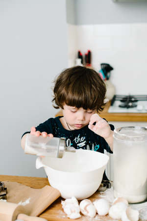 Son helps mother cook in the kitchen. High-quality photoの写真素材