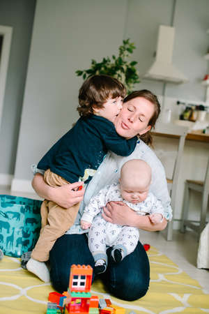 Mother plays with sons indoors. High quality photo