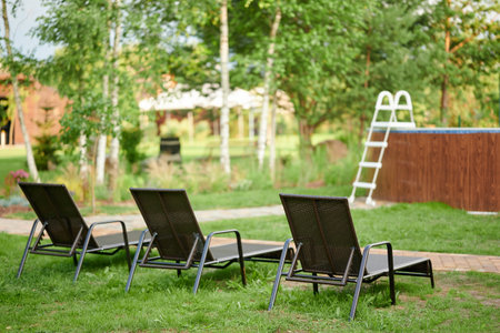 Sun Beds in the garden near pool on the green grass. High quality photo