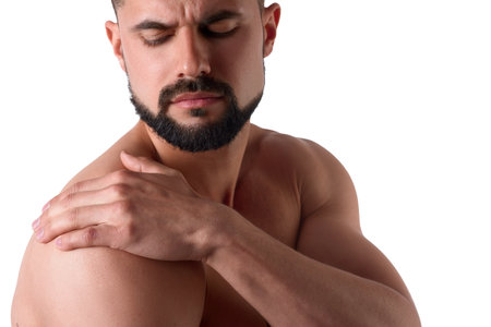Muscular strong man with shoulder pain, isolated on white background. Sportsman holds his sore shoulderの写真素材
