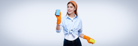 Housemaid wearing orange rubber gloves for hands protection washing with sponge. Cleaning or...
