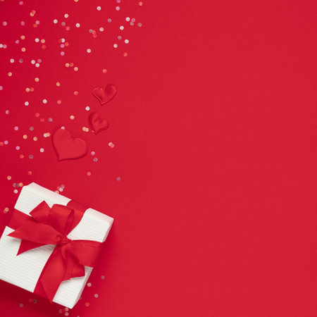 Gift box and soft hearts over red background. Template of Valentine's dayの写真素材