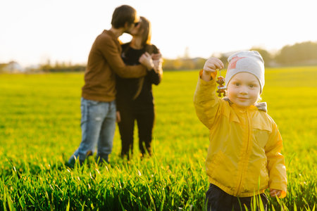 Young happy caucasian family has fun with child outdoors. Parents love son.の写真素材