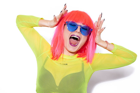 Screaming girl in pink wig, trendy blue sunglasses, and with bright lips on white background