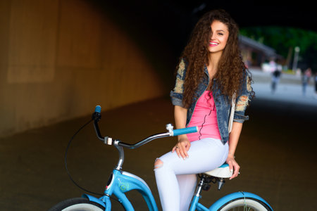 portrait of a beautiful sexy girl with a bicycle on city