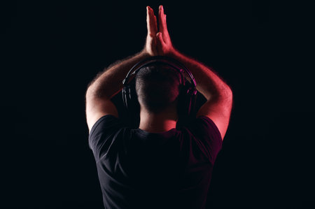 Back of dj in headphones clapping hands on black isolated background. International DJ Dayの写真素材