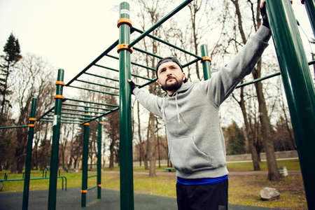 Young strong man prepares for training on a sports field in the summer in the cityの写真素材