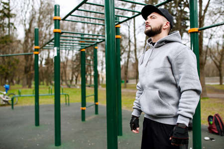 Young strong man prepares for training on a sports field in the summer in the cityの写真素材