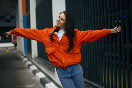 Young fashionable teenager girl walks around the city in the summer in a fashionable jacket and jeansの写真素材