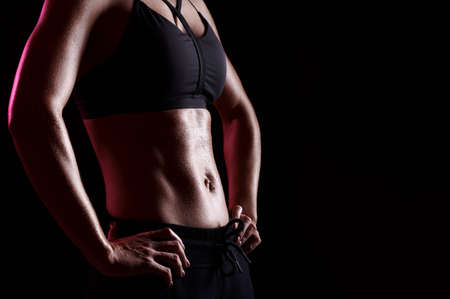 Strong perfect womans abs after training. Slim muscular female body with beads of sweat