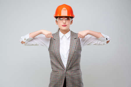Young woman engineer with protective orange paint and goggles holds do not lead my advertisement in front of youの写真素材