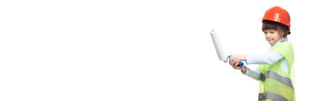 Kid standing with paint roller in hand. She is painting. Redecoration, repair and repaint concept.の写真素材