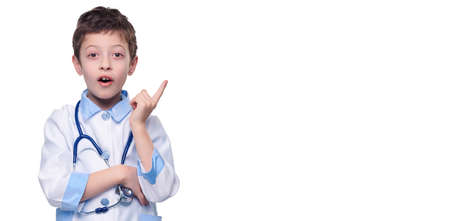 Excited boy doctor with stethoscope finger pointing on product on white isolated background. Healthy lifestyle conceptの写真素材