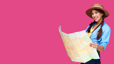 Smiling girl teen student in casual clothes and straw hat, backpack and digital camera holding map...