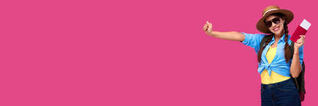 Excited female tourist holding passport and traveling tickets over pink isolate background. Woman student in summer casual clothes. Smiling caucasian woman in sunglasses.の写真素材
