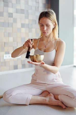Practice of standing on nails. Yoga woman meditation before stand on sadhu board with TIBETAN BOWLS. Concept on healthy lifestyle.の写真素材