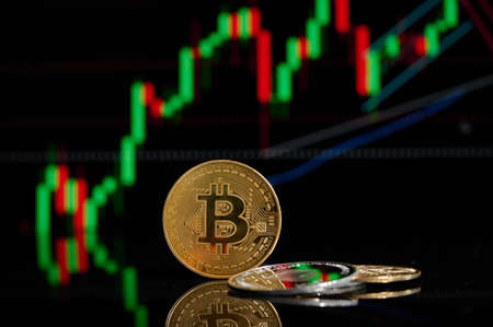 Bitcoin and Ethereum coins cryptocurrency with blurred candlestick chart in the background. Digital Bit Coin BTC Currency Technology Business Internet. Cryptocurrency and Decentralized finance conceptの写真素材