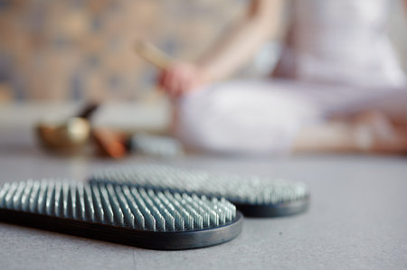 Selective focus, practice of standing on nails. Yoga woman meditation before stand on sadhu board. Concept of healthy lifestyleの写真素材
