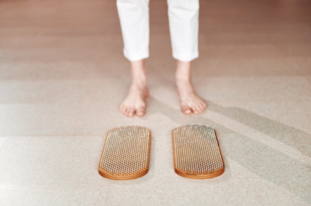 Cropped of woman standing near wooden sadhu board with nails before practice, yoga desk for regular...