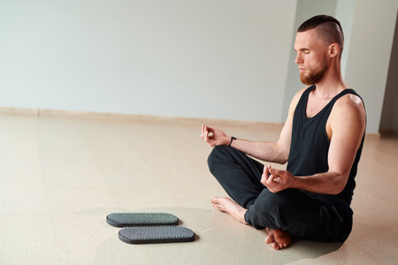 Practice of standing on nails. Man meditation before stand on sadhu board in yoga studio. Concept on healthy lifestyle.の写真素材