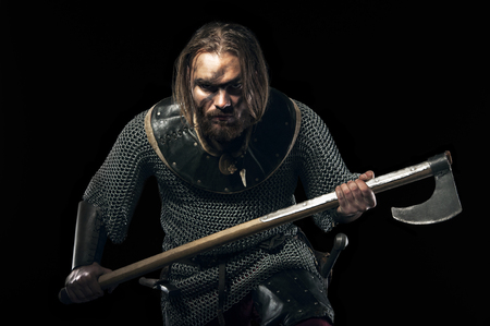 Photo of dangerous viking warrior with axe prepare to battle on black background.の写真素材